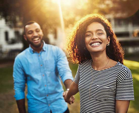 Young couple smiling and holding hands.