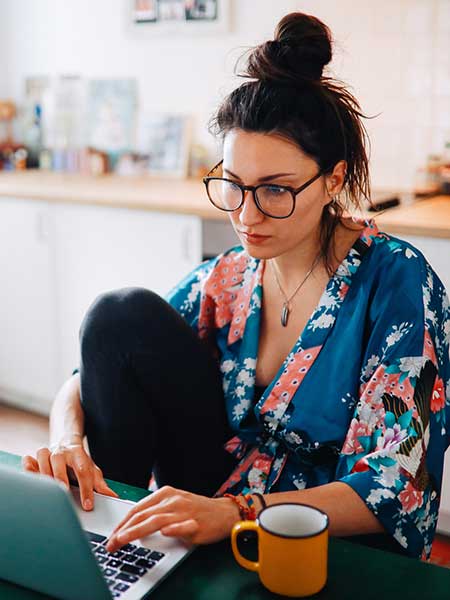 Woman working on laptop in kitchen